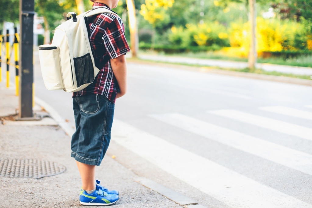child standing on a side walk